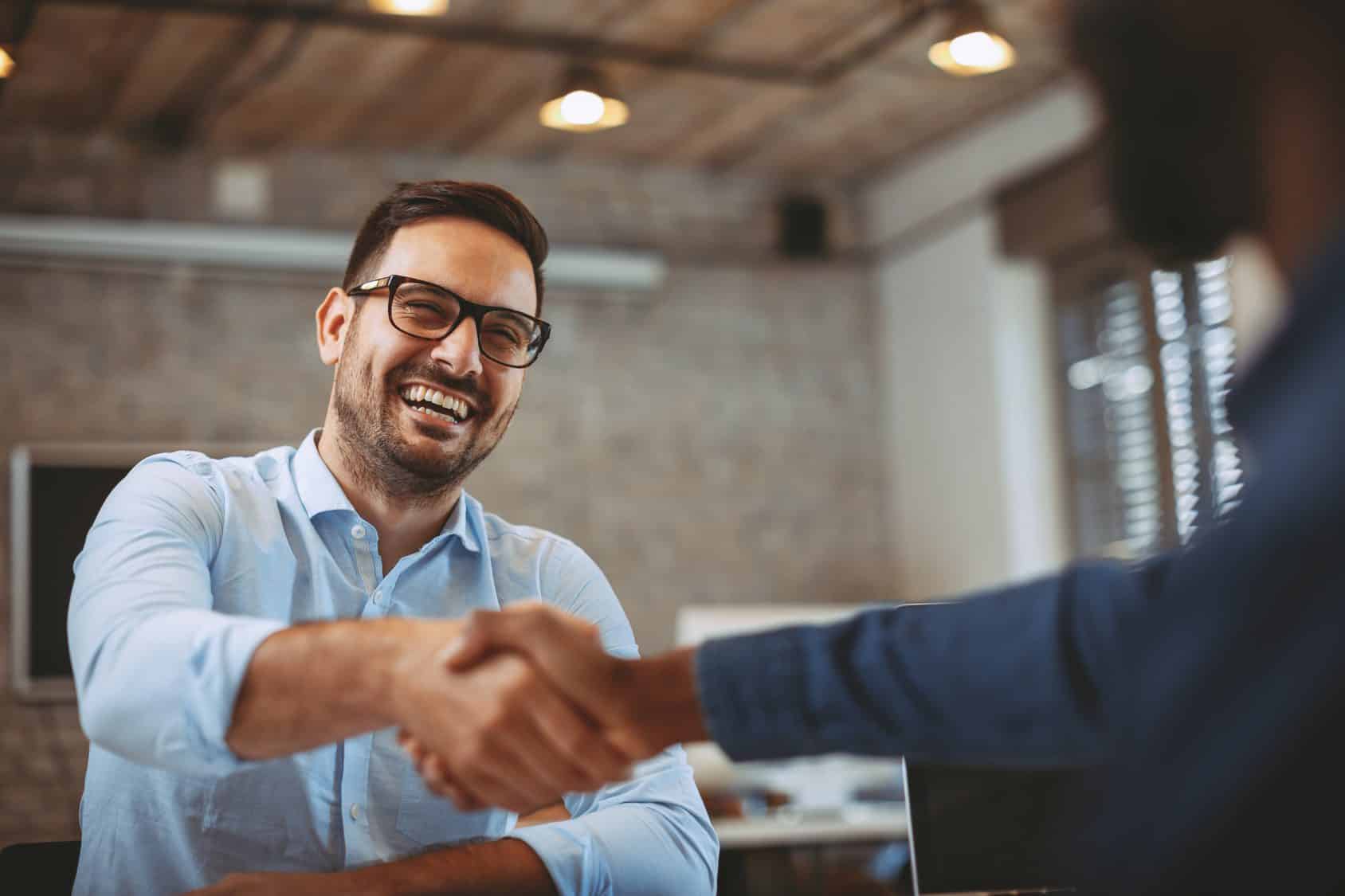 Man shaking hands with organisations stakeholder after discussing HR initiative